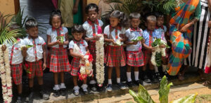 Kinder begrüssen uns mit Betelblättern und Girlanden